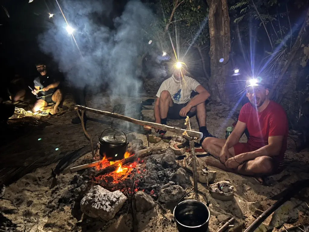 Campfire at night in the forest lit by headlamps