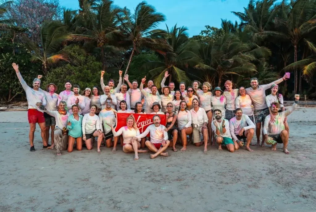 Large group celebrating together on the beach at the end of an expedition