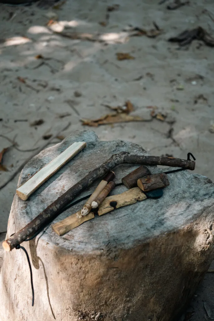 Bow drill fire starting kit on a tree stump, demonstrating how to start a fire with a bow drill.