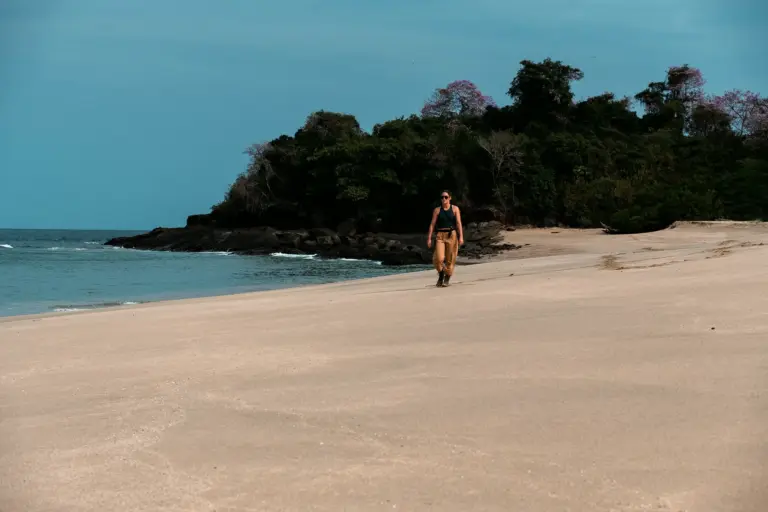 Woman walking light and unencumbered along an empty island beach in Panama