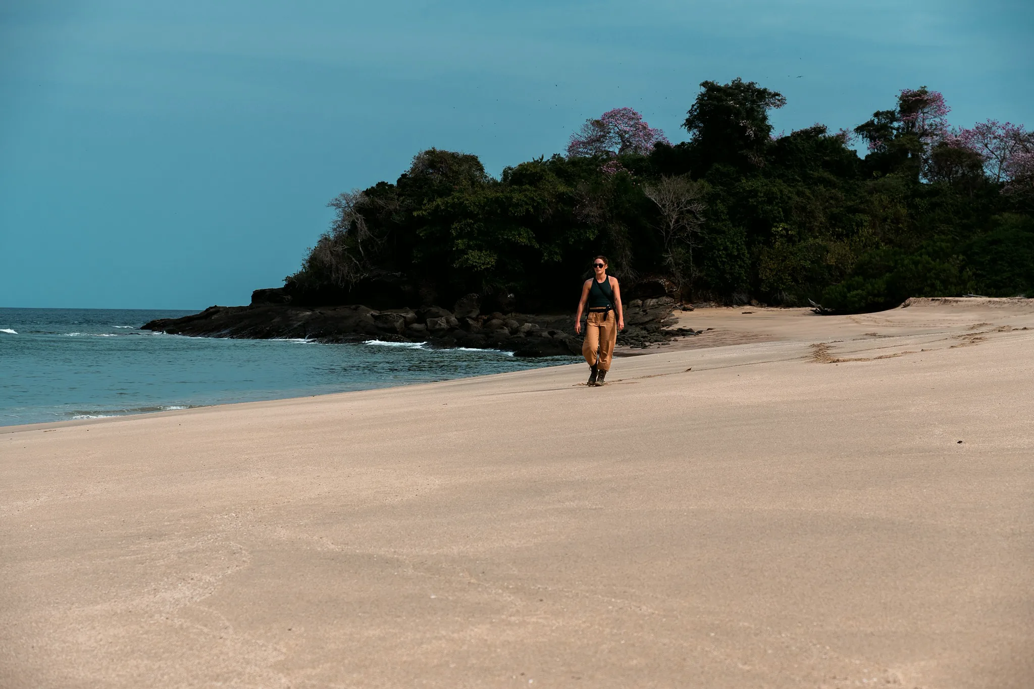 Woman walking light and unencumbered along an empty island beach in Panama