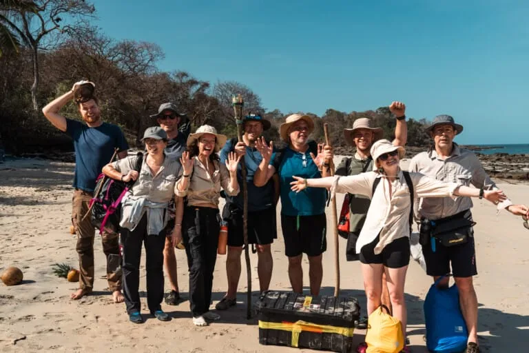 Adventure group on a tropical desert island beach, hiking and survival tips, outdoor expedition with backpackers.
