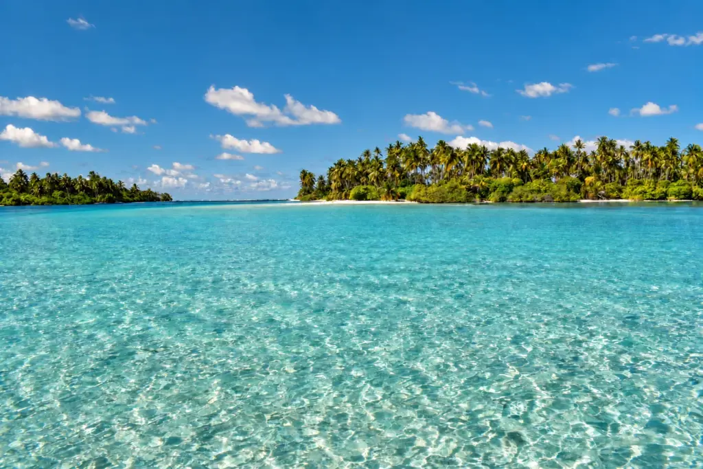 Clear turquoise lagoon and palm-covered islands in the Maldives