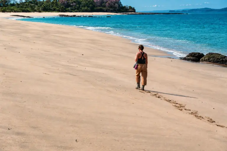 Woman walking alone along an empty tropical beach on a Desert Island Survival expedition in Panama
