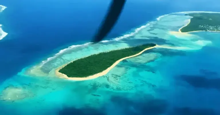 Aerial view of a tropical deserted island with lush greenery, white sandy beaches, and vibrant blue waters, perfect for.
