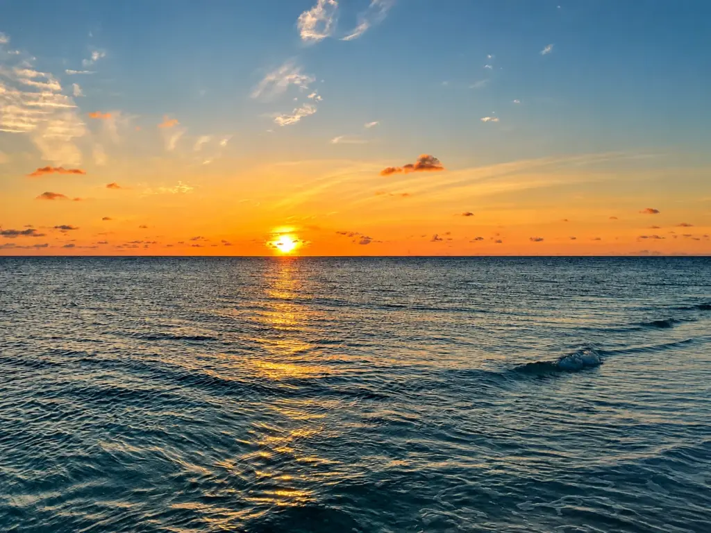 The sun sets over the calm Indian Ocean