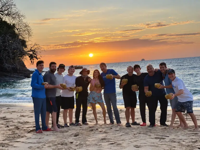 The expedition group lines up on the beach at sunset