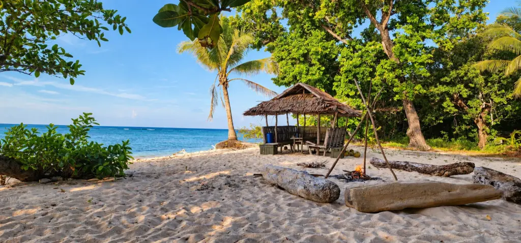 A thatched hut and campfire on a quiet Philippine beach