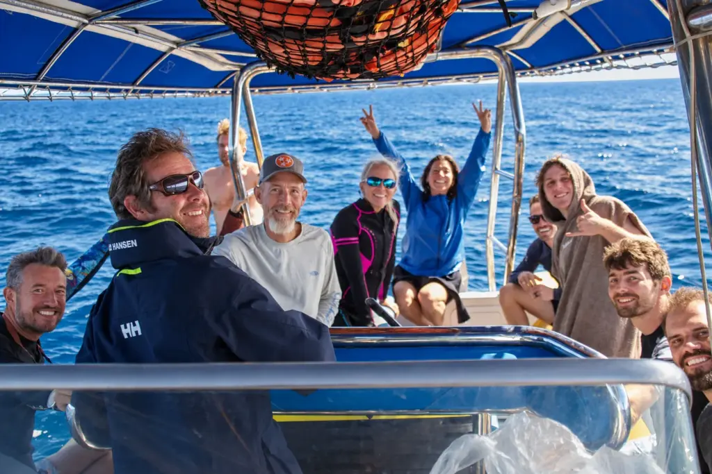 The group waves from the boat on the way to the island