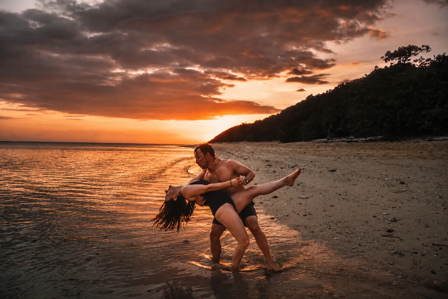 Couple dancing on a beach at sunset